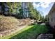 Landscaped backyard with stone retaining wall and grassy area at 19914 Wooden Tee Dr, Davidson, NC 28036