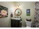 Well-appointed bathroom with a round mirror and marble vanity at 19914 Wooden Tee Dr, Davidson, NC 28036