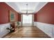 Formal dining room with red walls, hardwood floors, and a chandelier at 19914 Wooden Tee Dr, Davidson, NC 28036