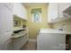 Laundry room with built-in ironing board and white cabinets at 19914 Wooden Tee Dr, Davidson, NC 28036