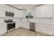 Modern kitchen with white cabinets, stainless steel appliances, and white tile backsplash at 207 Faulkner St, Clover, SC 29710