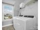 Well-lit laundry room with washer, dryer, and overhead shelving at 228 Pinnacle Xing, Shelby, NC 28152