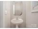 Small powder room with pedestal sink and mirror at 2604 Cochrane Dr, Charlotte, NC 28269