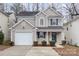 Two-story house with beige siding, a white garage door, and neatly landscaped front yard at 2604 Cochrane Dr, Charlotte, NC 28269