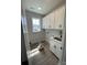 Well-lit laundry room features ample cabinetry, stainless steel sink, and a window at 3240 Mcharney Dr # 36, Harrisburg, NC 28075