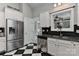 Kitchen features stainless steel refrigerator and dishwasher, white cabinets, and black and white checkered floor at 373 Battery Cir, Clover, SC 29710