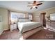 Main bedroom with ceiling fan, large windows, and ample closet space at 44743 Fish Camp Rd, New London, NC 28127