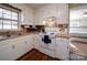 Bright eat-in kitchen with white cabinets, microwave, and view to backyard at 44743 Fish Camp Rd, New London, NC 28127