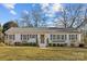 Charming ranch home with white brick exterior, gray shutters, and manicured lawn at 4526 Wedgewood Dr, Charlotte, NC 28210