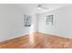 Bright bedroom featuring hardwood floors, two windows, a ceiling fan, and white trim at 5113 Grice Ct, Charlotte, NC 28210