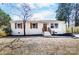 Charming white brick home featuring brown shutters, a wood door, and landscaped front yard at 5113 Grice Ct, Charlotte, NC 28210