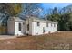 Rear view of a charming white brick ranch house with a large backyard at 5113 Grice Ct, Charlotte, NC 28210