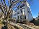 Three-story townhome with light-colored siding, landscaping, and a sidewalk at 9323 Lenox Pointe Dr, Charlotte, NC 28273