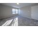 Bright bedroom with neutral walls and carpet, featuring a large window and ample closet space at 10502 Haddington Nw Dr, Charlotte, NC 28269