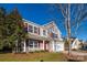 Two-story house with taupe vinyl siding, red accents, and a two-car garage at 10502 Haddington Nw Dr, Charlotte, NC 28269