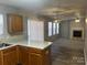 Open kitchen with island, looking into living room with fireplace at 10502 Haddington Nw Dr, Charlotte, NC 28269