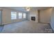 Living room with fireplace, carpet, and ceiling fan at 10502 Haddington Nw Dr, Charlotte, NC 28269