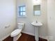 Convenient powder room with pedestal sink and dark floors at 14916 Oregon Oak Ct, Mint Hill, NC 28227