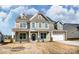 Two-story house with a neutral color palette and a three-car garage at 3229 Mcharney Dr # 35, Harrisburg, NC 28075