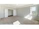 Bright bedroom with neutral walls and carpet, featuring multiple windows and an adjacent door at 3237 Mcharney Dr # 29, Harrisburg, NC 28075