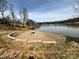 Relaxing lakefront firepit area with stone retaining wall and gravel at 4339 Reed Creek Dr, Sherrills Ford, NC 28673