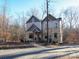 Two-story home with stone and wood siding, inviting porch, and landscaped yard at 600 E Monbo Rd, Statesville, NC 28677