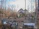 House nestled in woods with seating area and landscaping at 600 E Monbo Rd, Statesville, NC 28677