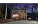 Night view of a home with a stone facade and neutral siding, softly illuminated by interior and porch lighting at 600 E Monbo Rd, Statesville, NC 28677