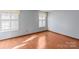 Bedroom with wood flooring and two windows with shutters at 6619 Wagon Oak Rd, Charlotte, NC 28212