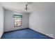 Simple bedroom with blue carpet and ceiling fan at 6619 Wagon Oak Rd, Charlotte, NC 28212