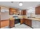 Galley kitchen with wood cabinets and tiled floor at 6619 Wagon Oak Rd, Charlotte, NC 28212