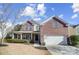 Brick two-story house with a two-car garage and landscaped yard at 7647 Black Hawk Ln, Tega Cay, SC 29708