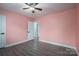 Bedroom with pink walls, wood-look floors, and hallway access at 7704 Woodland Hills Rd, Hickory, NC 28602