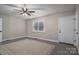 Bright bedroom featuring a ceiling fan, large window, and neutral color scheme at 7704 Woodland Hills Rd, Hickory, NC 28602