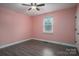 Bedroom with pink walls and grey wood-look floors at 7704 Woodland Hills Rd, Hickory, NC 28602