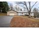 Ranch style home with gray siding, attached garage, and a tree in the front yard at 7704 Woodland Hills Rd, Hickory, NC 28602