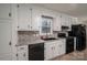 Kitchen with white cabinets, granite counters, and black appliances at 7704 Woodland Hills Rd, Hickory, NC 28602