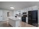 Kitchen with white cabinets, granite island, and black appliances at 7704 Woodland Hills Rd, Hickory, NC 28602