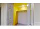 Basement closet with yellow walls and a shelf at 9175 Cox Rd, Mount Pleasant, NC 28124