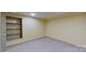 Basement room with built-in shelving and grey flooring at 9175 Cox Rd, Mount Pleasant, NC 28124