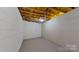 Empty, unfinished basement with light-grey flooring and white walls at 9175 Cox Rd, Mount Pleasant, NC 28124