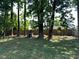 Backyard with tall trees, grassy lawn, and a wood fence at 9624 Langston Mill Rd, Charlotte, NC 28216