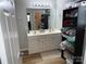 Bathroom with double sink vanity, well lit mirror, and shelving for storage at 9624 Langston Mill Rd, Charlotte, NC 28216