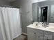 Bathroom featuring double vanity sinks and a shower with a white curtain at 9624 Langston Mill Rd, Charlotte, NC 28216