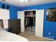 Bedroom featuring blue walls, a bed and an open closet with clothes and storage organizers at 9624 Langston Mill Rd, Charlotte, NC 28216