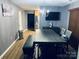 Dining room featuring wood-look flooring, gray walls, modern lighting, and a nearby kitchen entrance at 9624 Langston Mill Rd, Charlotte, NC 28216