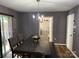 Open dining area with modern chandelier, dining table and visible laundry room at 9624 Langston Mill Rd, Charlotte, NC 28216