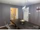 Open dining area with modern chandelier, dining table and visible laundry room at 9624 Langston Mill Rd, Charlotte, NC 28216