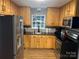 Charming kitchen featuring wood cabinets, stainless steel appliances, and granite countertops at 9624 Langston Mill Rd, Charlotte, NC 28216