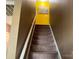 Carpeted staircase with neutral walls and a bright yellow accent wall leading to the upper level of the home at 9624 Langston Mill Rd, Charlotte, NC 28216